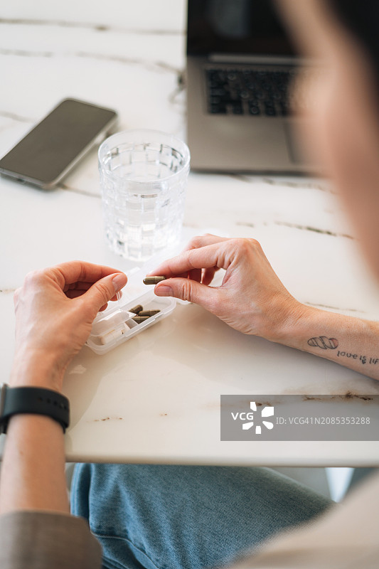 年轻女人在办公室打开药盒图片素材