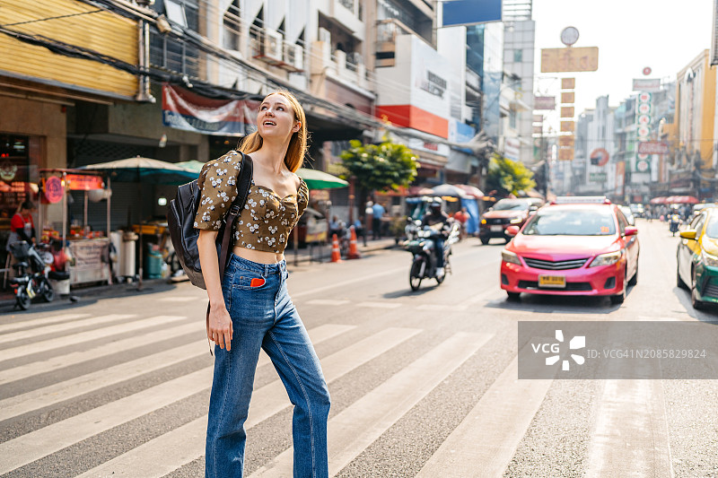 在泰国曼谷唐人街过马路的年轻女游客图片素材