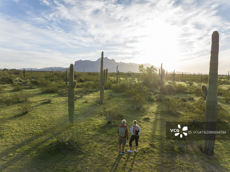 清晨航拍徒步者探索沙漠图片素材