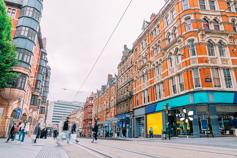 伯明翰市中心商店和公寓前的模糊行人长曝光图片素材