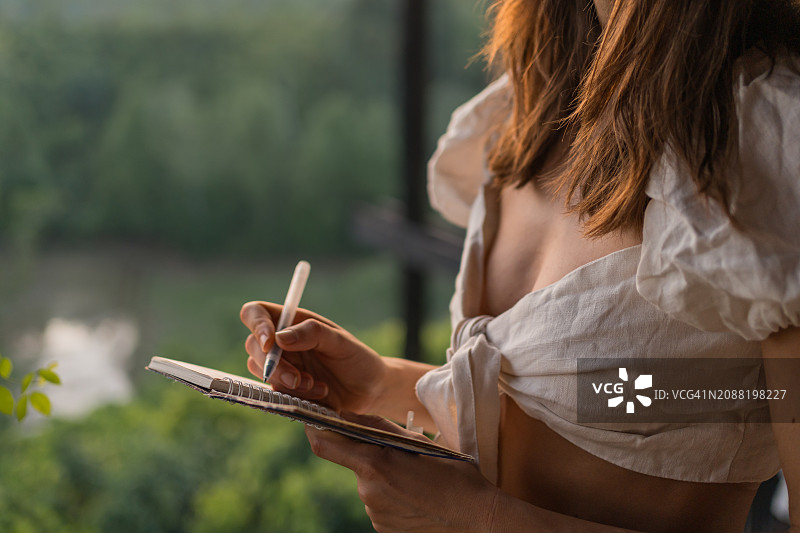 年轻女子在便签簿上写字图片素材