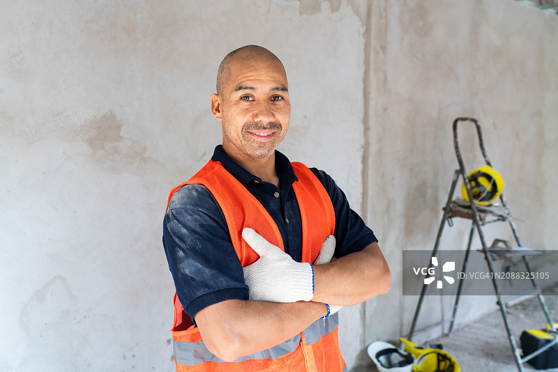 站在翻新工地的自信建筑工人图片素材