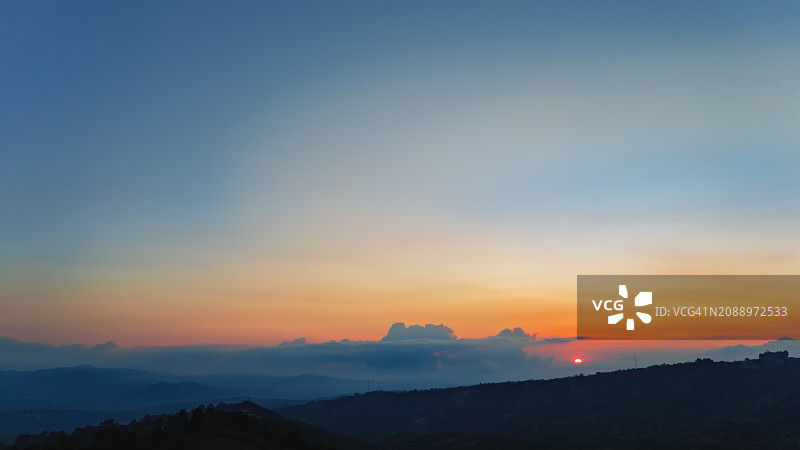 日落时分温暖的广阔天空和红色太阳图片素材