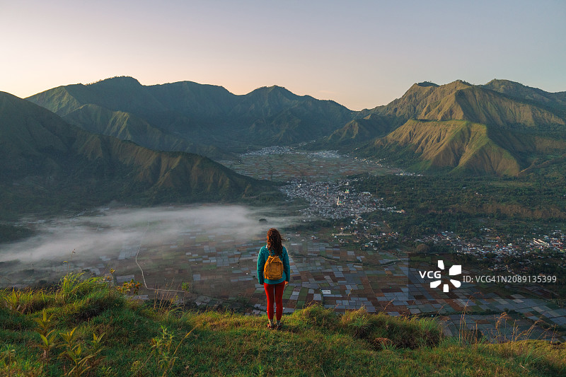 徒步后站在龙目岛林贾尼火山附近的观景台上的女人图片素材