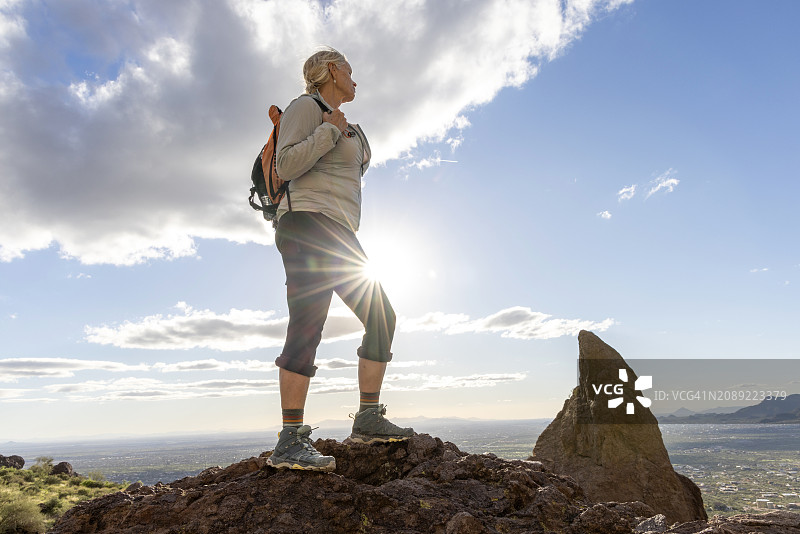 徒步旅行者在岩石悬崖顶上欣赏风景图片素材