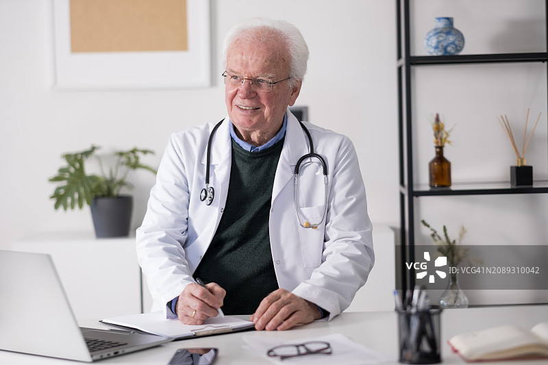 年长医生在办公室使用电脑工作图片素材