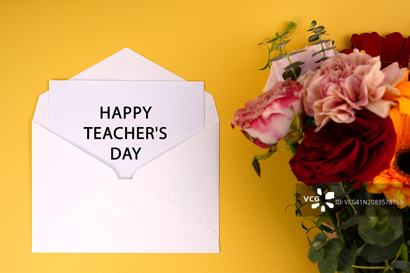 白色信封与教师节快乐祝福语和混合花束在黄色背景上图片素材