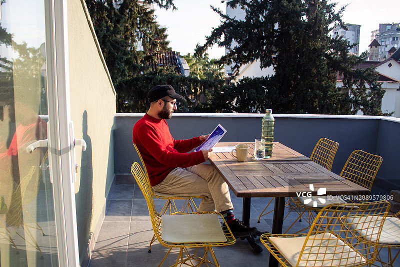 男人在阳台上阅读图片素材