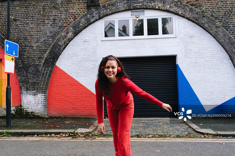 戴耳机的红衣滑板少年图片素材