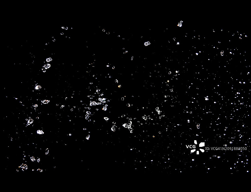 黑色背景上的水花飞溅和水滴运动图片素材