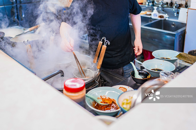 菲律宾马尼拉厨师用筷子在大锅里炸小吃（未露脸）图片素材