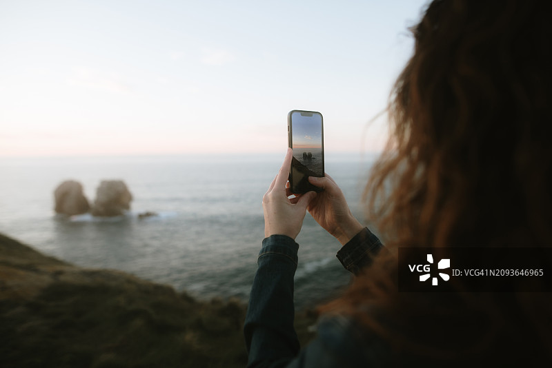 女人用智能手机拍照图片素材