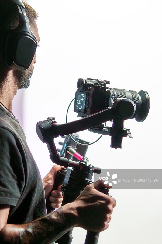 在室内使用云台工作的摄影师图片素材