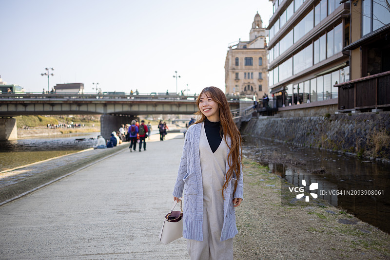 在河边散步的女性游客图片素材