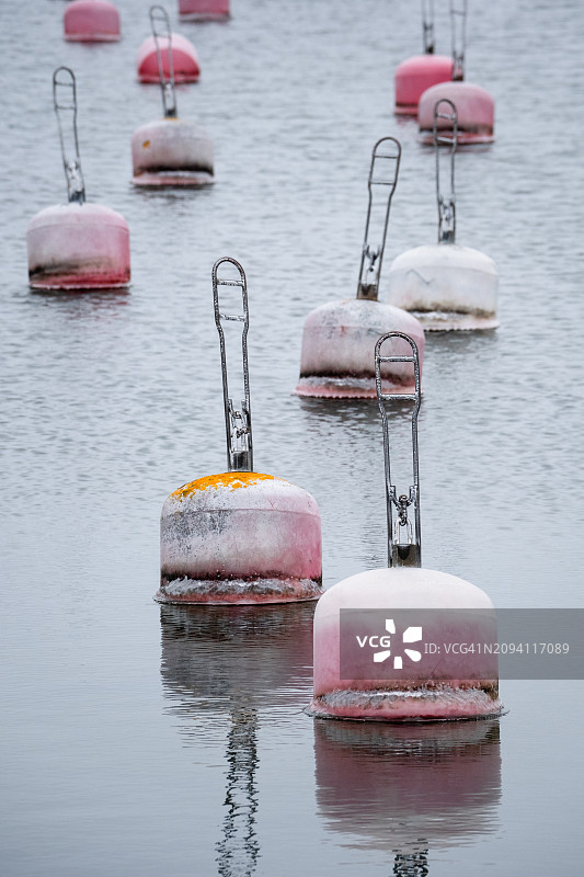 波罗的海静止海港中褪色的粉红色风化浮标图片素材