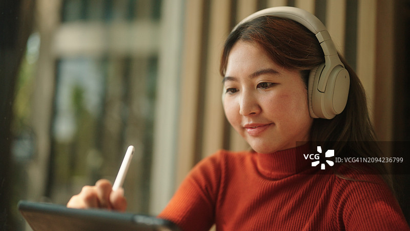 亚洲女性在平板电脑上绘画图片素材