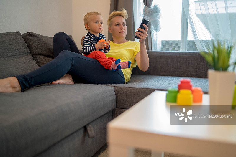 两个人，母子，单亲母亲家庭正在换台看电视图片素材