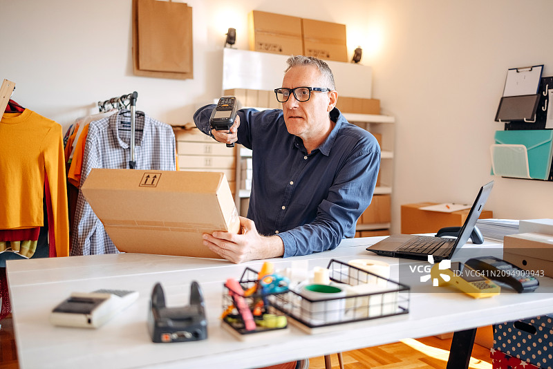 男人使用条形码扫描器打包货物准备发货图片素材