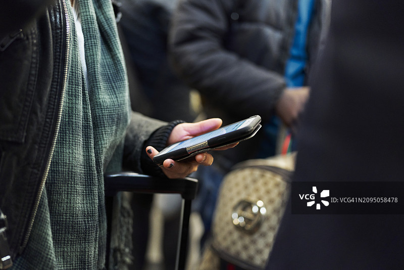 女游客在地铁内查看手机的侧视图图片素材