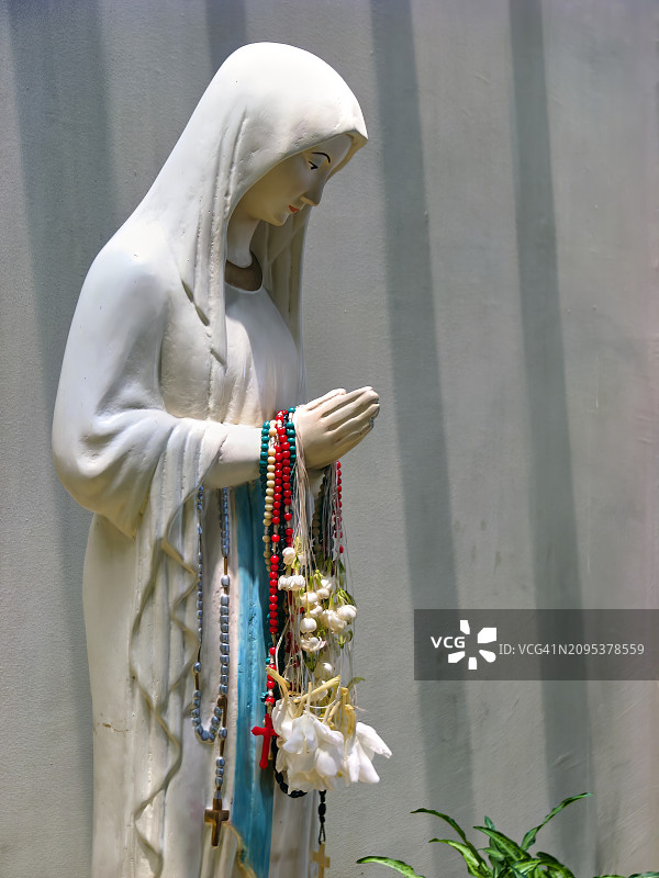 手持念珠的圣母玛利亚雕像侧面特写图片素材