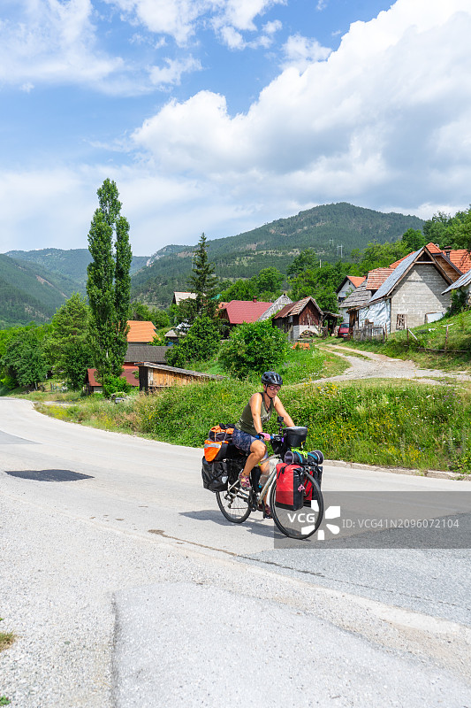骑着砾石自行车的单人骑行者在乡村风景中穿行图片素材