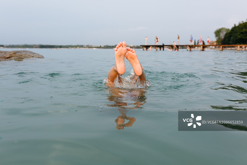湖中溅起水花的孩子脚部图片素材