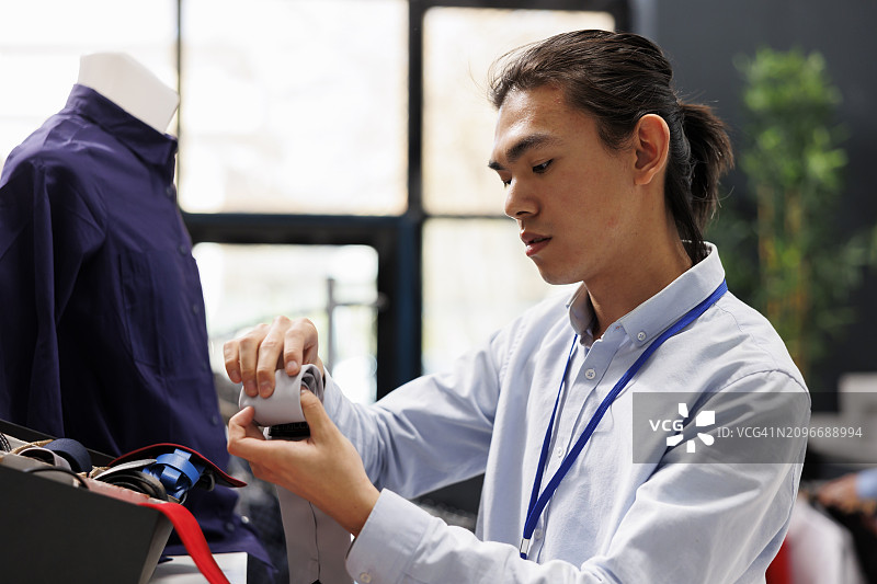 销售员和顾客在商店查看服装图片素材