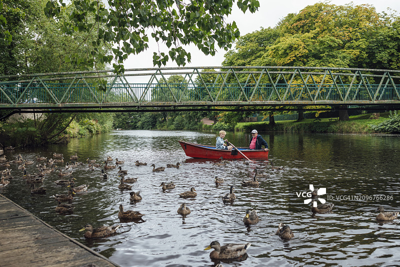 小男孩和爷爷一起划船图片素材