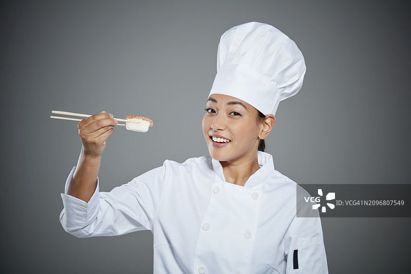 年轻厨师用筷子夹寿司的肖像图片素材