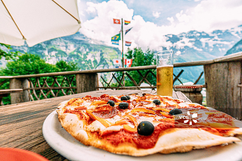 瑞士吉梅尔瓦尔德的肉类蔬菜至尊披萨和啤酒的广角照片图片素材