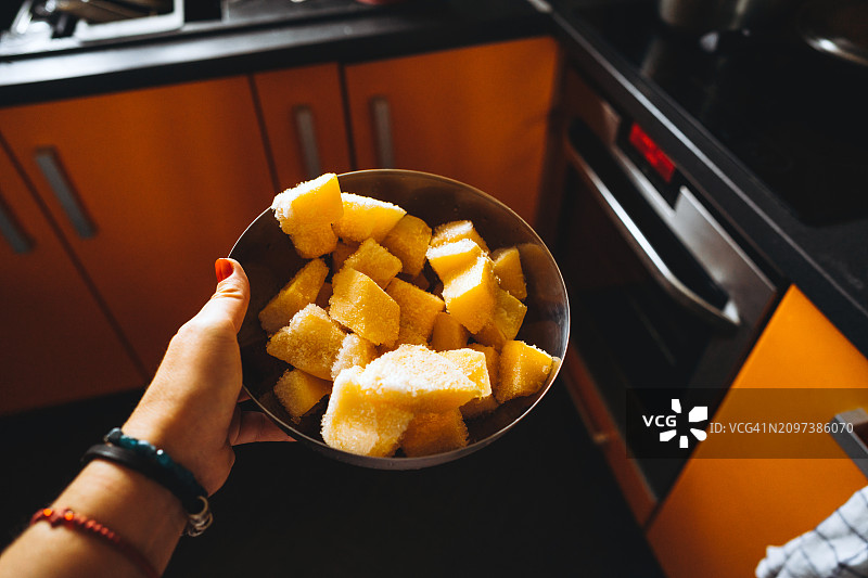 大金属碗中带有霜冻涂层的冷冻南瓜块图片素材