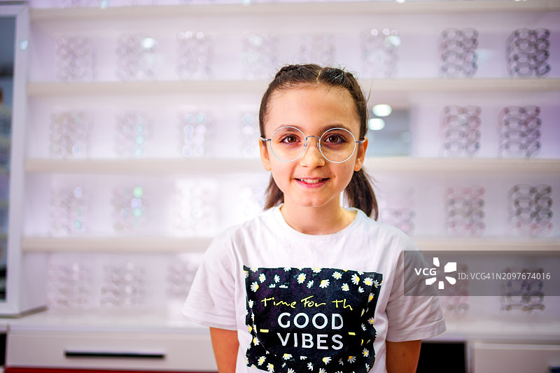 试戴眼镜的微笑小女孩图片素材