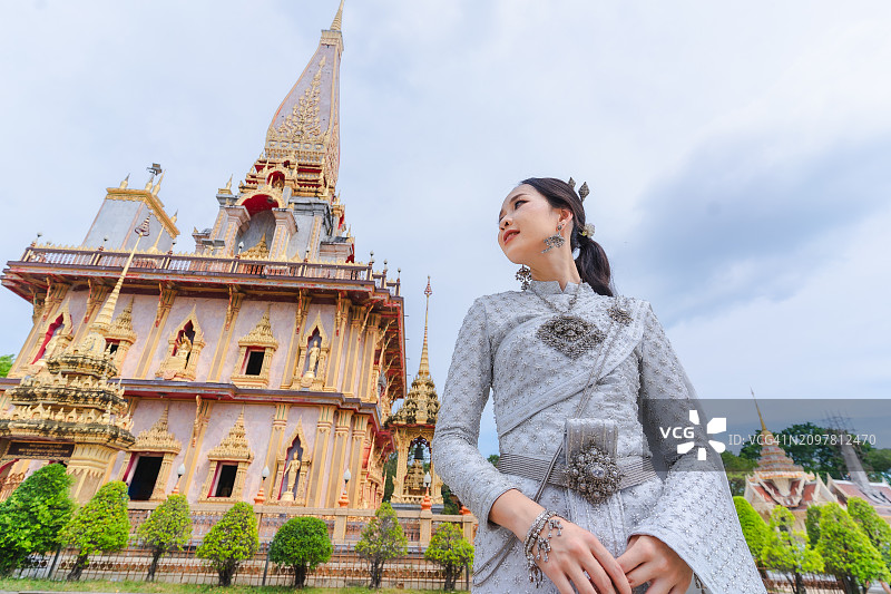 穿着白色泰国连衣裙的女人在查龙寺快乐地微笑图片素材