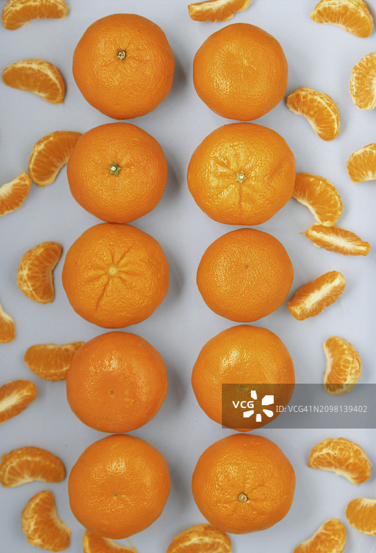 蓝色背景上排列成两排的克莱门汀橘子和果皮图片素材