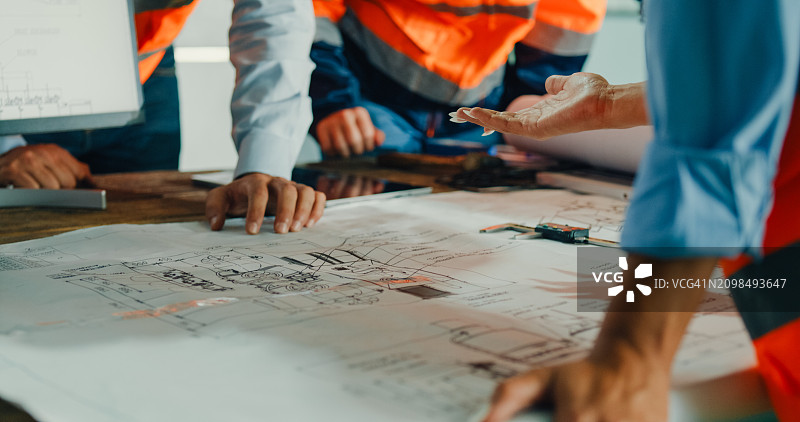 工业工程师团队开会分析机械蓝图，在制造工厂的桌子上咨询项目特写图片素材