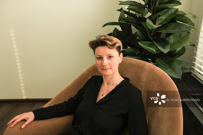 坐在棕色扶手椅上的女孩肖像图片素材