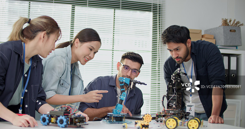 各民族人士参与现代手部机器人学习项目图片素材