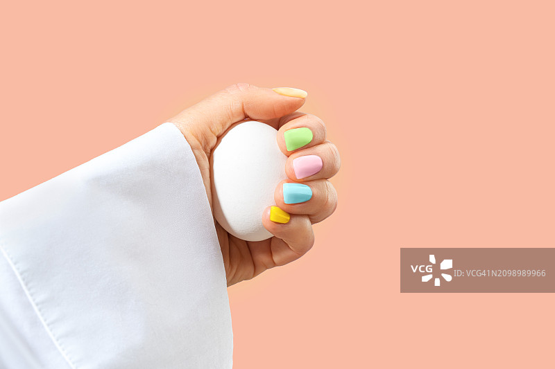 优雅女人的手，复活节假日色彩的柔和色美甲图片素材