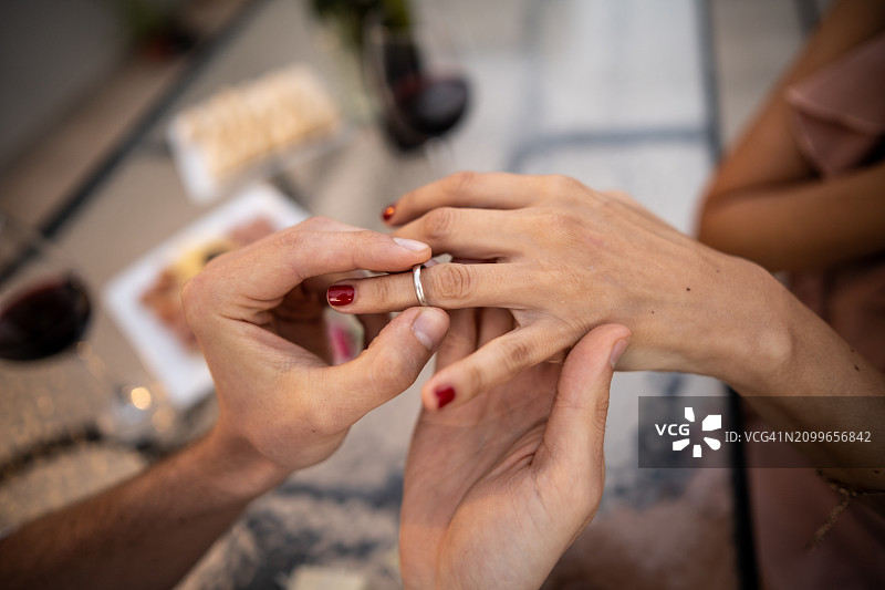 男人在屋顶上给女友戴订婚戒指特写图片素材