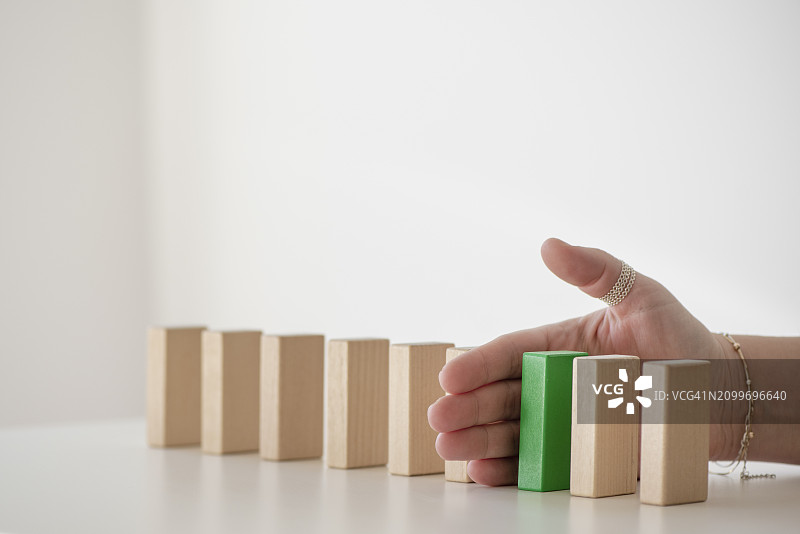 人手阻止方块掉落桌面图片素材