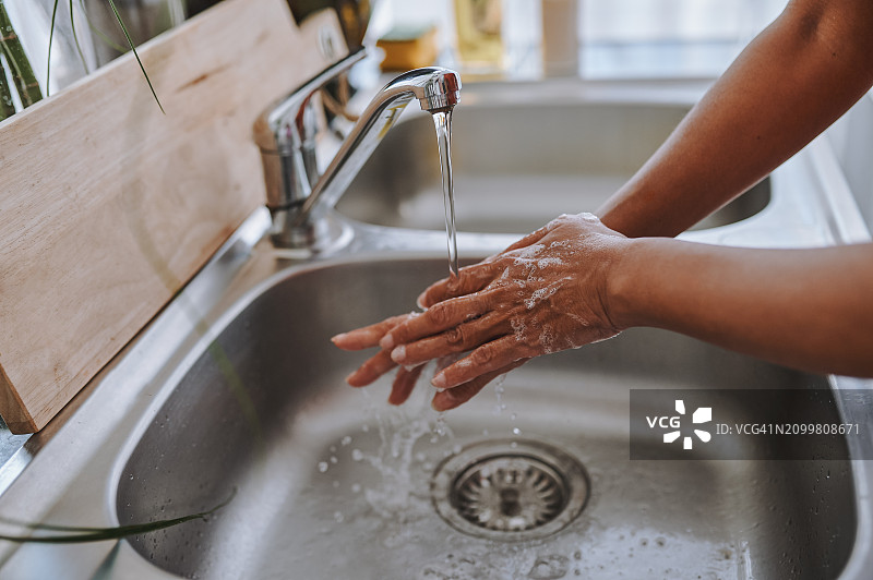 俯视角度拍摄的女子在厨房水槽用肥皂洗手图片素材