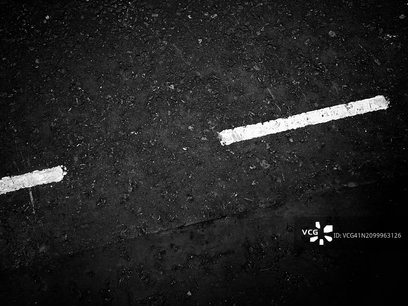 英国伦敦街道黑色沥青上的白色线条：道路标记特写图片素材