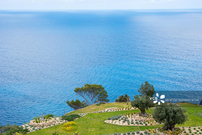 春季宁静海景：梯田花园、草地、岩石床、树木、薰衣草和 Affodill图片素材