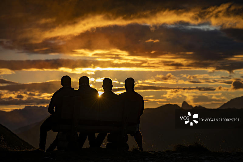 人们惊叹于蒙塔丰山脉在日落时分壮观多云的天空，奥地利福拉尔贝格州蒙塔丰雷蒂康查格斯，欧洲图片素材