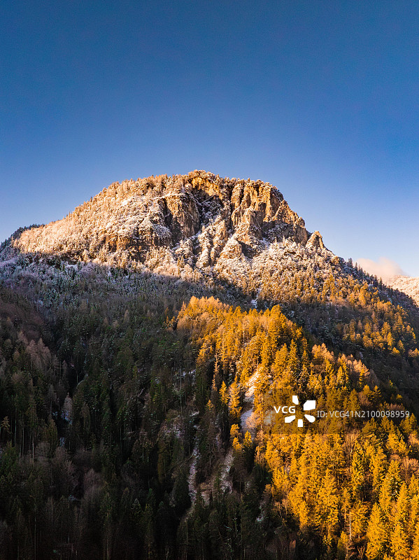 德国巴伐利亚州贝希特斯加登阿尔卑斯山脉的雪山和秋季森林图片素材
