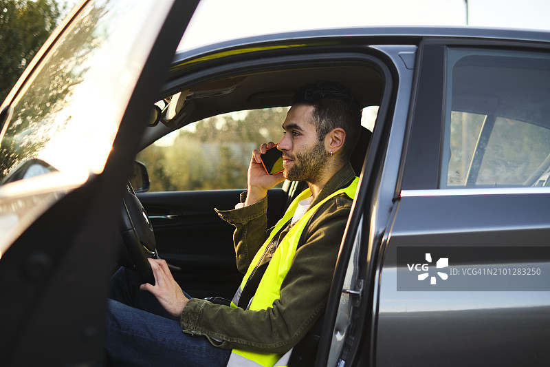 男人坐在破车里用手机通话图片素材