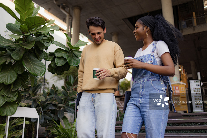 快乐的大学朋友们在楼梯上边走边聊图片素材