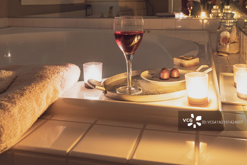 奢华点燃的蜡烛泡泡浴，巧克力和葡萄酒图片素材