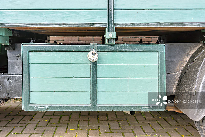 卡车下带挂锁的绿色木制储物箱图片素材