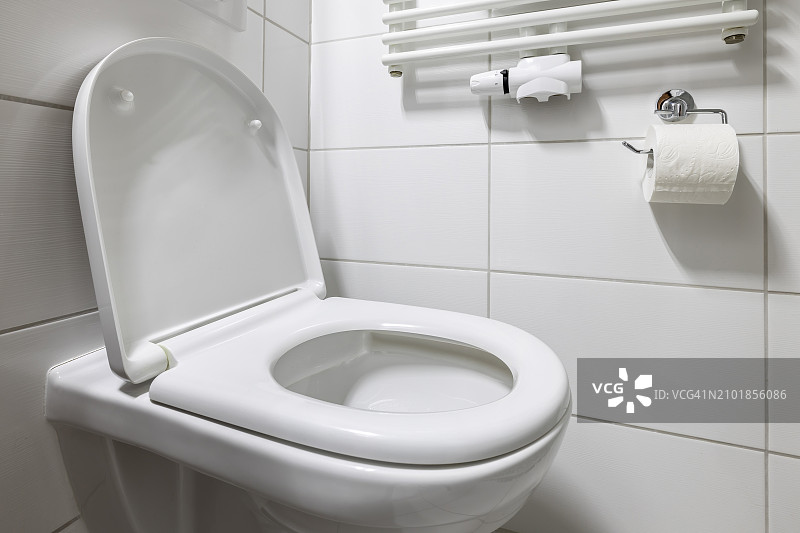 现代卫生间，带马桶、加热器和卫生纸卷图片素材